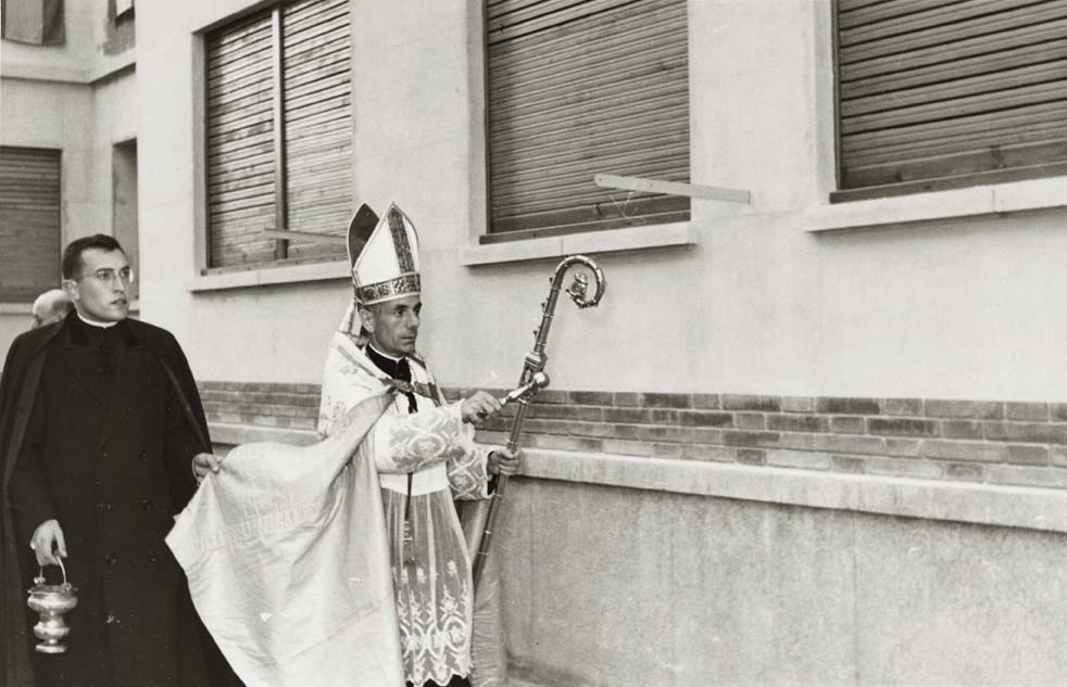 Foto en blanc i negre del Bisbe auxiliar de Vic beneint les cases de Manresa 