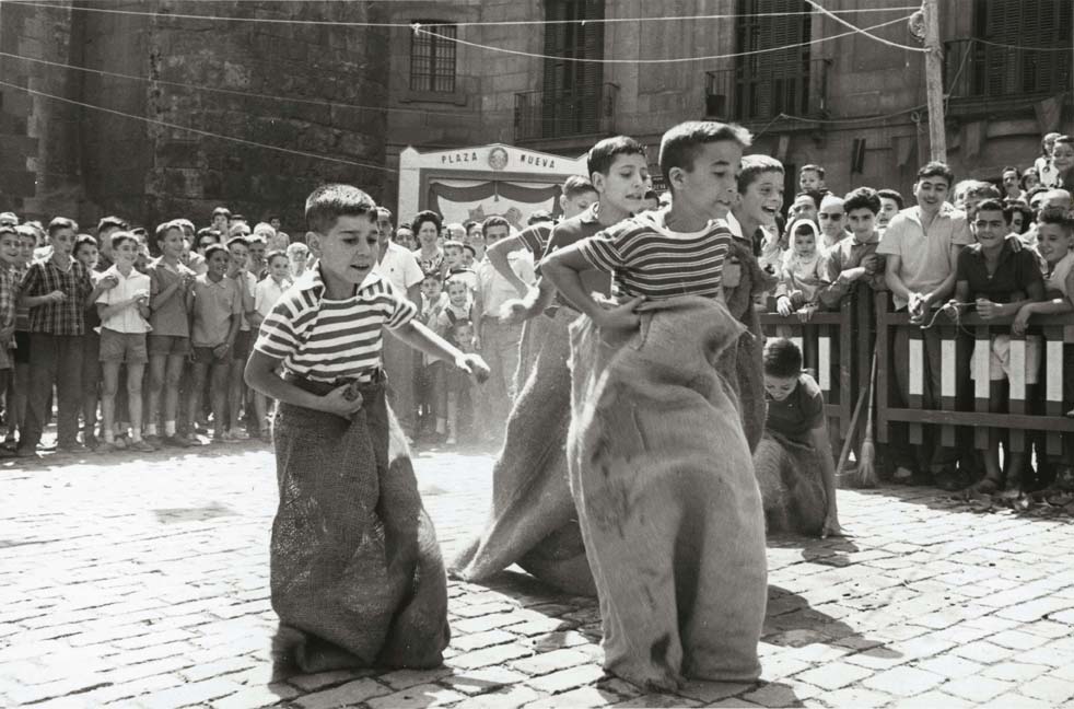 Foto en blanc i negre de nens fent una cursa de sacs a les Festes de Sant Roc