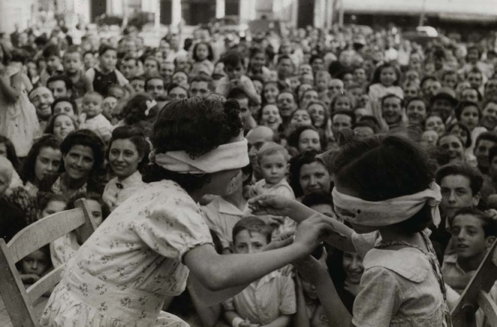 Foto en blanc i negre de nens jugant amb els ulls tapats a la Festa Major de Parel·lel