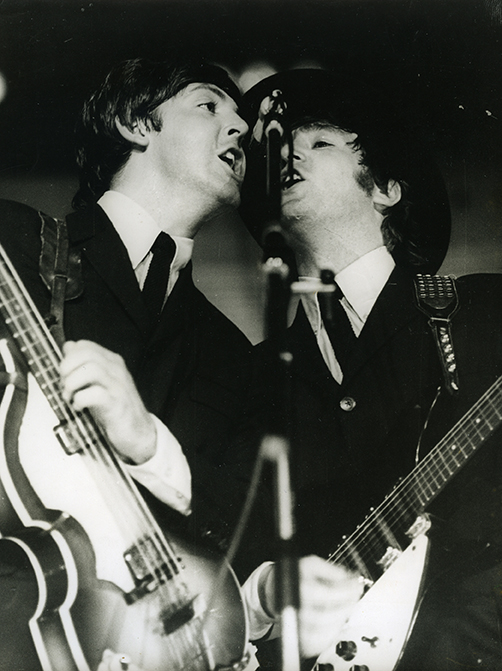 Foto en blanc i negre. Es veuen cantant els membres dels Beatles John Lennon i Paul Mccartney  en el concert de Barcelona