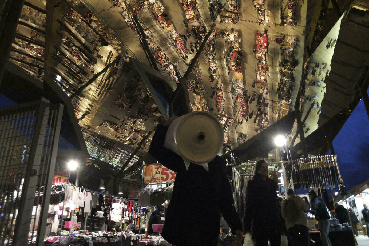 Fotografia del sostre mirall del mercats dels Encants on es veu els visitants del mercat reflectits en el sostre