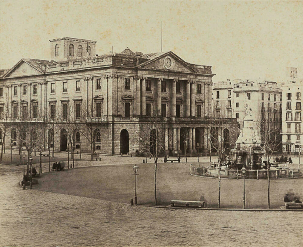 Foto en blanc i negre. Es veu edifici de la Llotja i la plaça Palau a finals de segle dinou