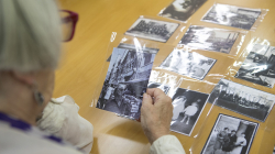 An elderly woman looking at old photos