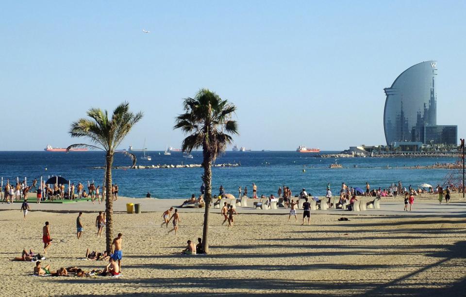 Persones jugant al futbol a la platja de la Barceloneta 