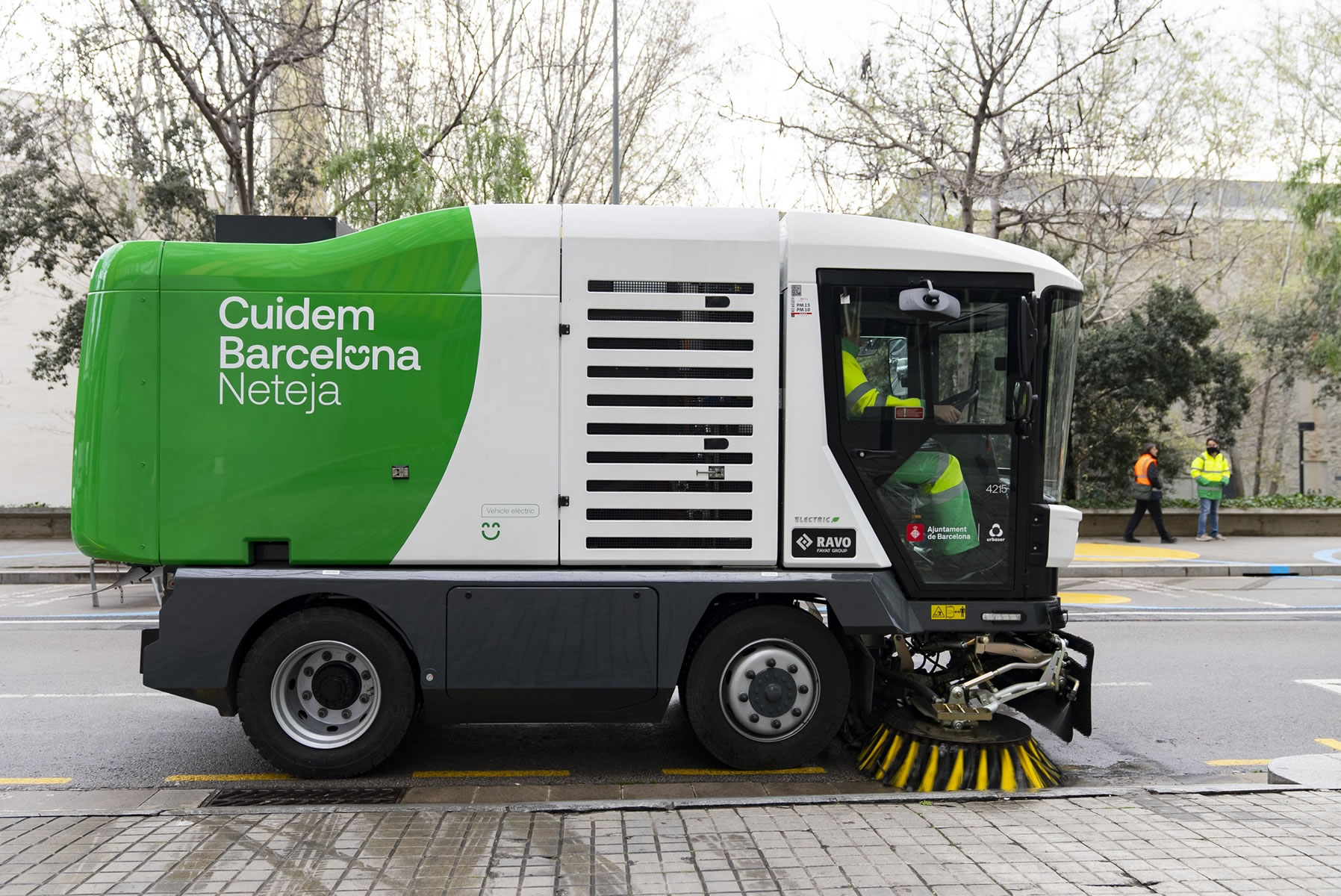Vehículo aspirador del servicio de limpieza urbano circulando y limpiando la vía 
