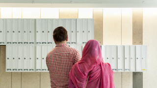 Un home i una dona musulmans, a la porteria d'un edifici d'habitatge públic