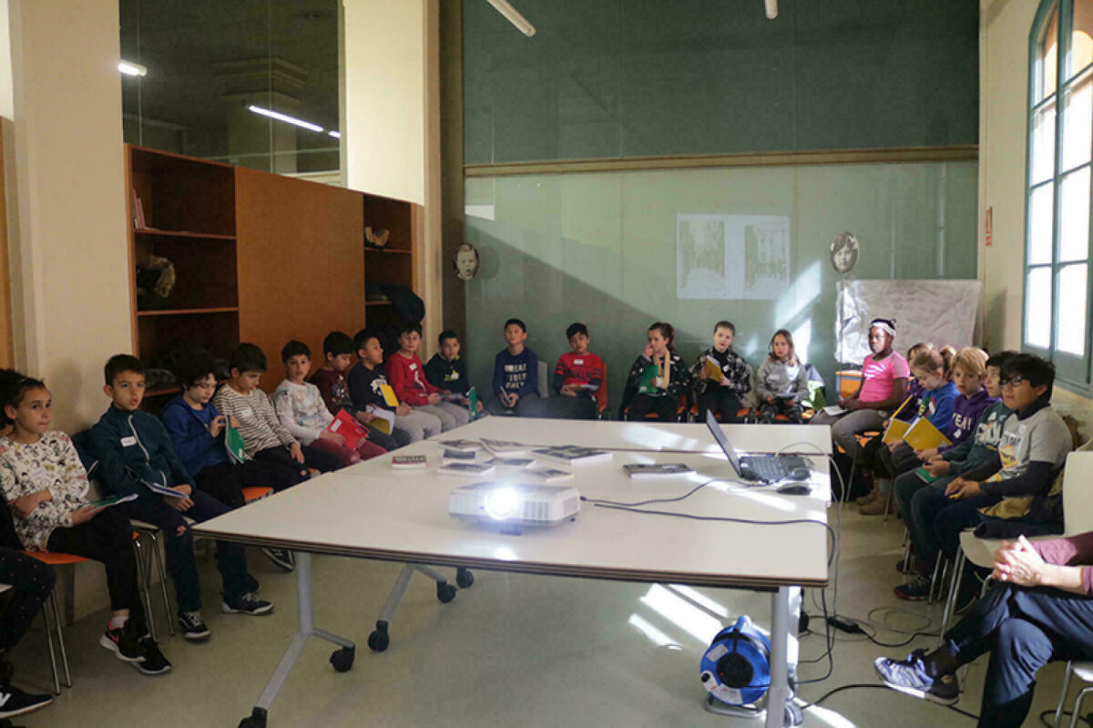 Fotografia on es veuen infants d'una escola fent un taller