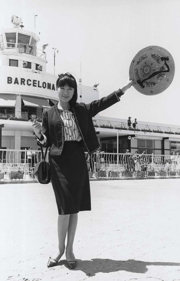 La foto en blanc i negre que retrata l'actriu xinesa Tiny Young a la seva arribada a l'aeroport, té un barret tradicional xinès a la mà