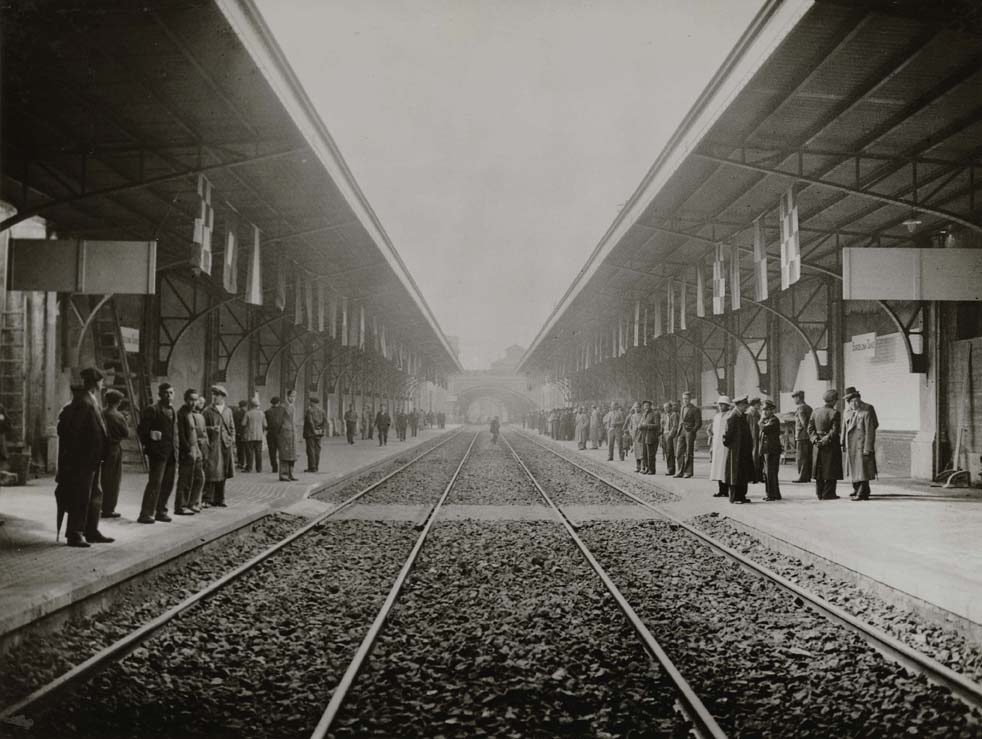 Foto en blanc i negre, vista des de les vies del tren la gent a la inauguració de l'Estació de Sants