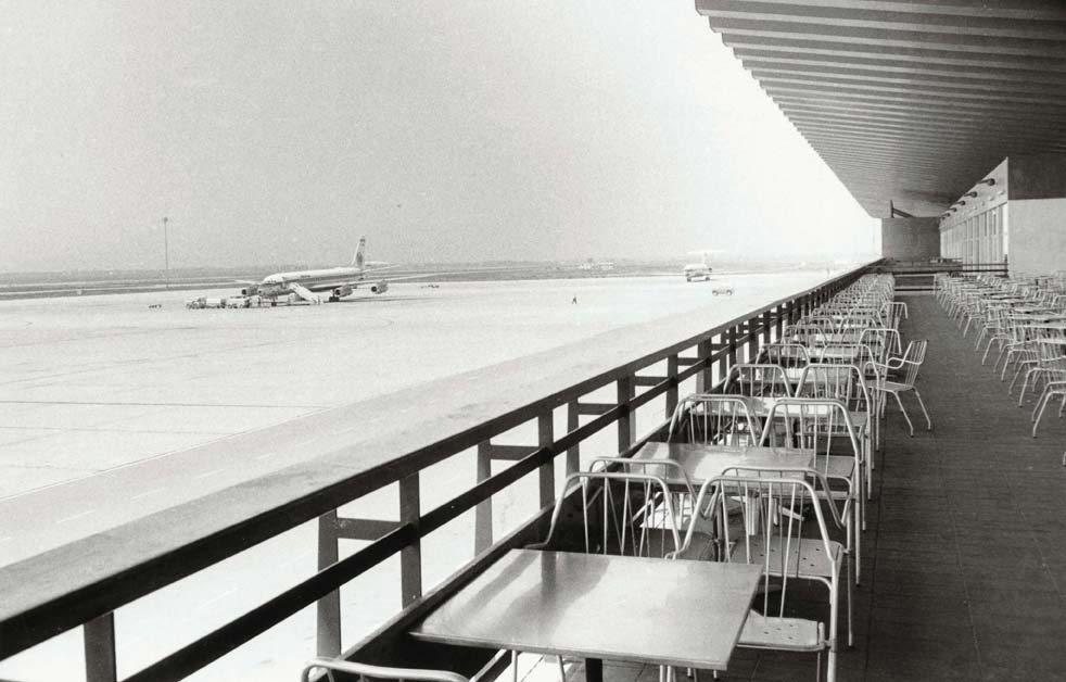  Foto en blanc i negre de les taules buides i l'avió  aturat al fons, a causa de la aturada dels aeroports en protesta pel segrest d'avions.