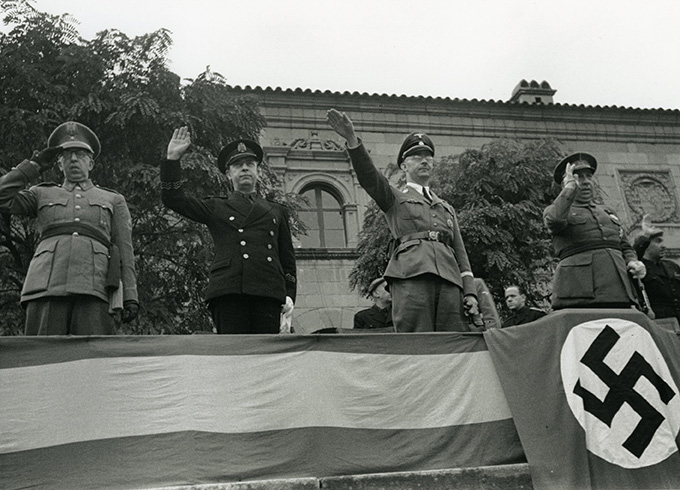 Foto en blanc i negre de Heinrich Himmler saludant durant el festival de danses i cançons populars organitzat per la Falange al Poble Espanyol