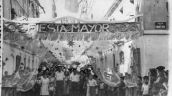 Group of local residents standing at the end of a decorated street during the big annual festival. 1945. Author unknown. La Barceloneta People’s Archive Collection. AMDCV