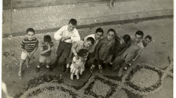 Retrat d'uns nens al costat d'una catifa de flors a Sarrià. 1970. Autor desconegut. Col·lecció fotogràfica d’arxius familiars de l’AMDSG