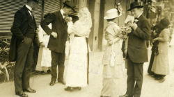 Women placing flowers in the lapels of foreign men during the "Flower Festival” walks organised by the Women‘s Federation Against Tuberculosis. 12/04/1914. Josep Maria Sagarra Plana. Editorial López. Photographic Archive of Barcelona