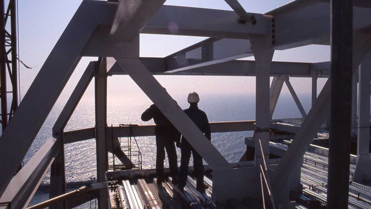 Una pareja de obreros mirando el mar desde las alturas. Autor desconocido (AFB)