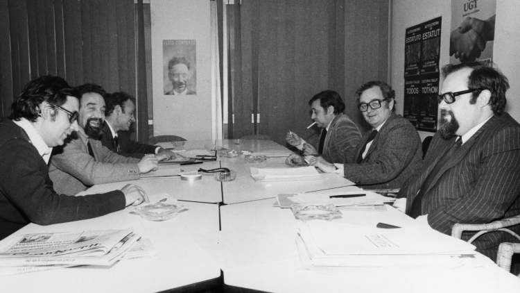 Business meeting between representatives of the PSUC and PSC on 12 April 1979. To the left, PSUC members Jordi Borja (at the back) and Antoni Gutiérrez Díaz, El Guti (in the middle); to the right, PSC members Carlos Cigarran Rodil (at the back), Joan Reventós (in the middle) and Francesc Martí Jusmet, in the foreground.