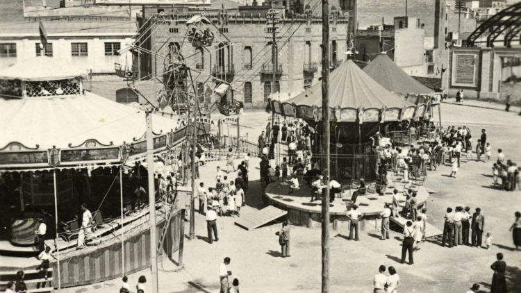 Carousels and a big wheel in plaça de Sants during the local festival, author unknown, 1939. Catalonia-Sants Hikers Union Photograph Collection. AMDS. 