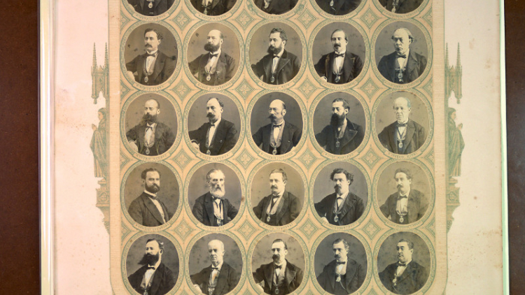 Orla con retratos de los 28 miembros del equipo de gobierno de 1870, todos son hombres y van vestidos de épcoa, algunos además lucen grandes bigotes y barbas