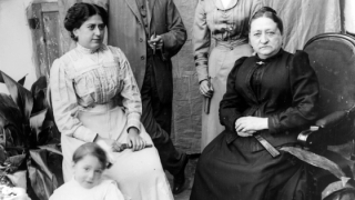 Imatge d'una família de finals del segle XIX: al fons s'observa un matrimoni de mitjana edat, drets i, al seu davant, hi ha dues dones assegudes, una d'elles d'edat avançada mentre que l'altra sembla més jove que el matrimoni de fons. Aquesta última, a davant, hi té una nena petita, també asseguda.