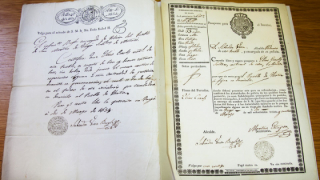 Close-up of two documents, one fully hand-written and the other printed with some hand-writing on it.