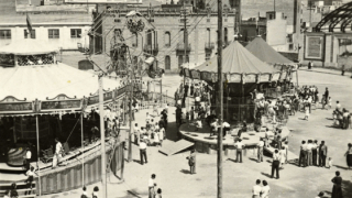 Tiovivo y una noria en la plaza de Sants durante la fiesta mayor, autor desconocido, 1939. Colección de fotografías de la Unió Excursionista de Catalunya de Sants. AMDS. 