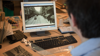 Una persona està mirant a través de la pantalla d’un ordinador una fotografía antiga en blanc i negre del carrer Salmerón