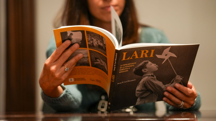 Dona llegint el llibre Lari, de fotografia domèstica.