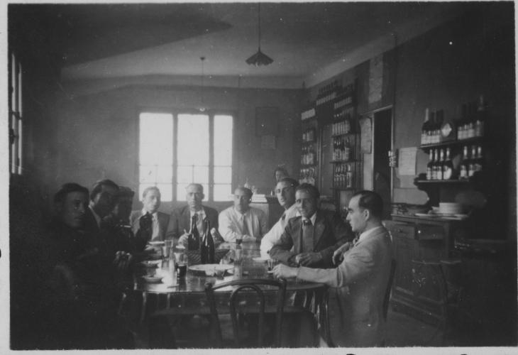 Homes asseguts a la taula d'un bar