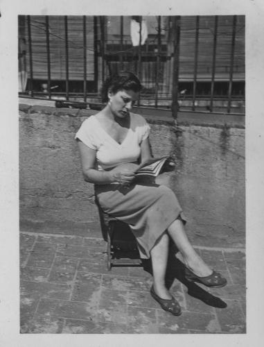 Dona asseguda llegint al terrat