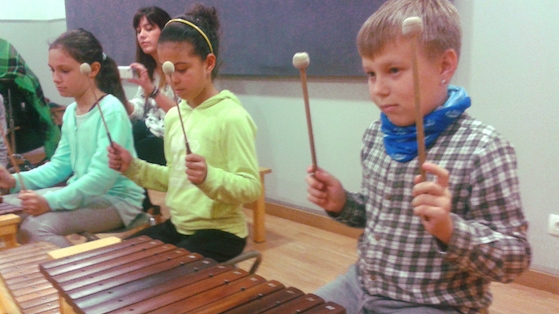 Nens i nenes de l'escola Mediterrània realitzant els tallers musicals  a Xamfrà 
