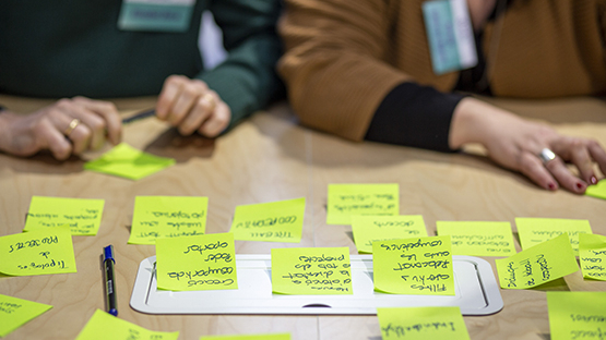 notes autoadhesives amb apunts sobre una taula en una jornada educativa