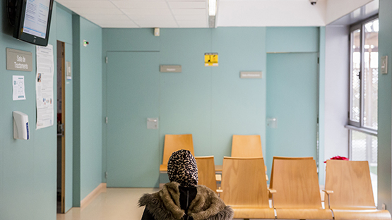 una mujer sentada en la sala de espera de un centro de salud