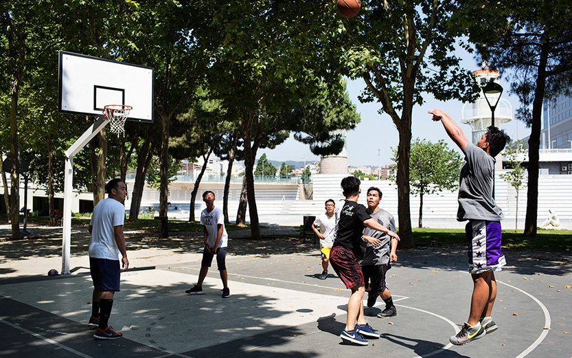 joves jugant a basquet a un parc