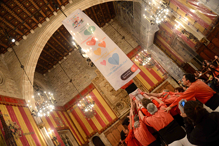 Los Castellers de Barcelona haciendo un pilar y desplegando una pancarta con los valores del Año de la Familia