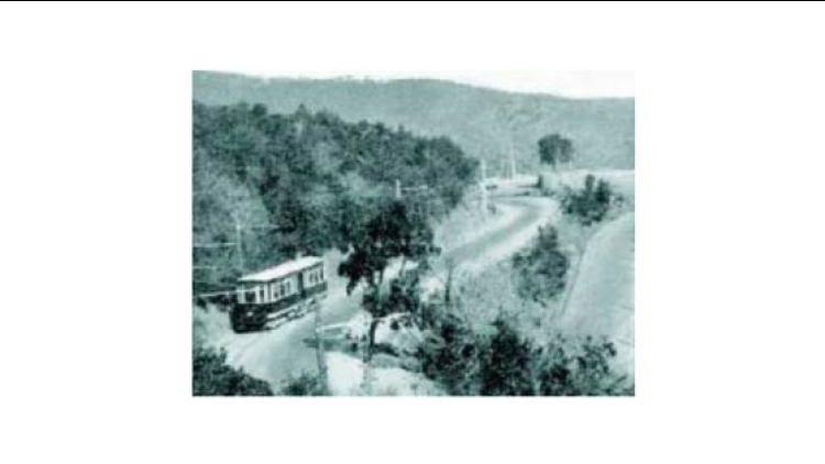 Un dels cotxes del tramvia de la Rabassada al costat del revolt de la paella