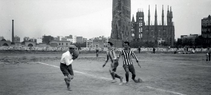 Partit de futbol al camp de l'Europa, cap al 1915 amb la Sagrada Família al fons