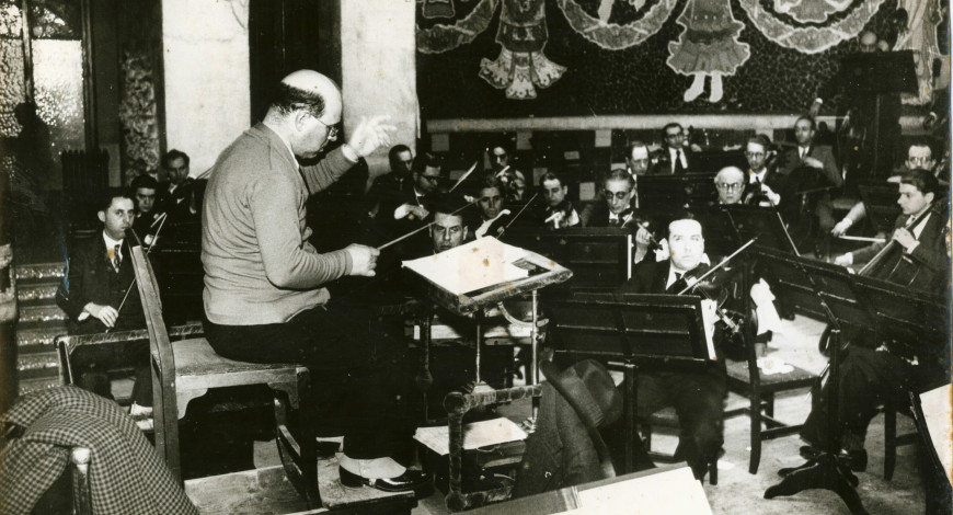 Pau Casals dirigint un assaig de l’Orquestra Pau Casals al Palau de la Música Catalana. Autor: Pérez de Rozas. 1934. Fons Pau Casals.  
