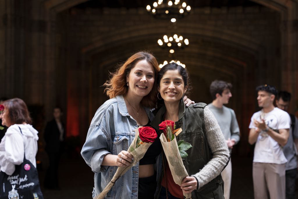 Dues dones mostren les seves roses solidàries comprades a les parades de les entitats situades al pati de l'Ajuntament de Barcelona