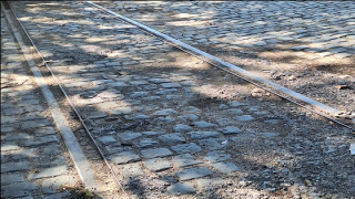 Detall de lae vies del tramvia sobre la vella calçada de llambordes