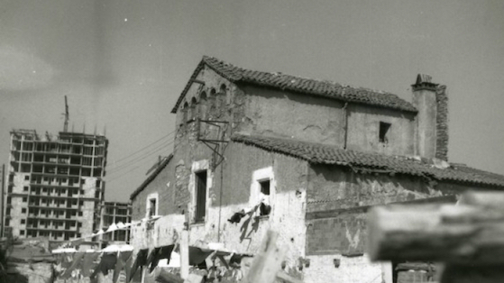Contrast entre la masia Can Canals i el bloc d'habitatges en construcció al darrera. 1960 -1980 aprox