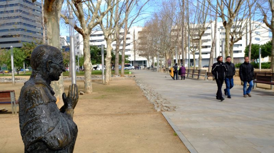 jardins de Gandhi amb l'escultura de Gandhi i un grup d'homes passejant pel costat