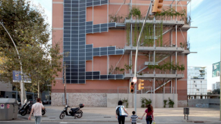 Plaques solars a la mitgera d'un edifici del carrer Granada